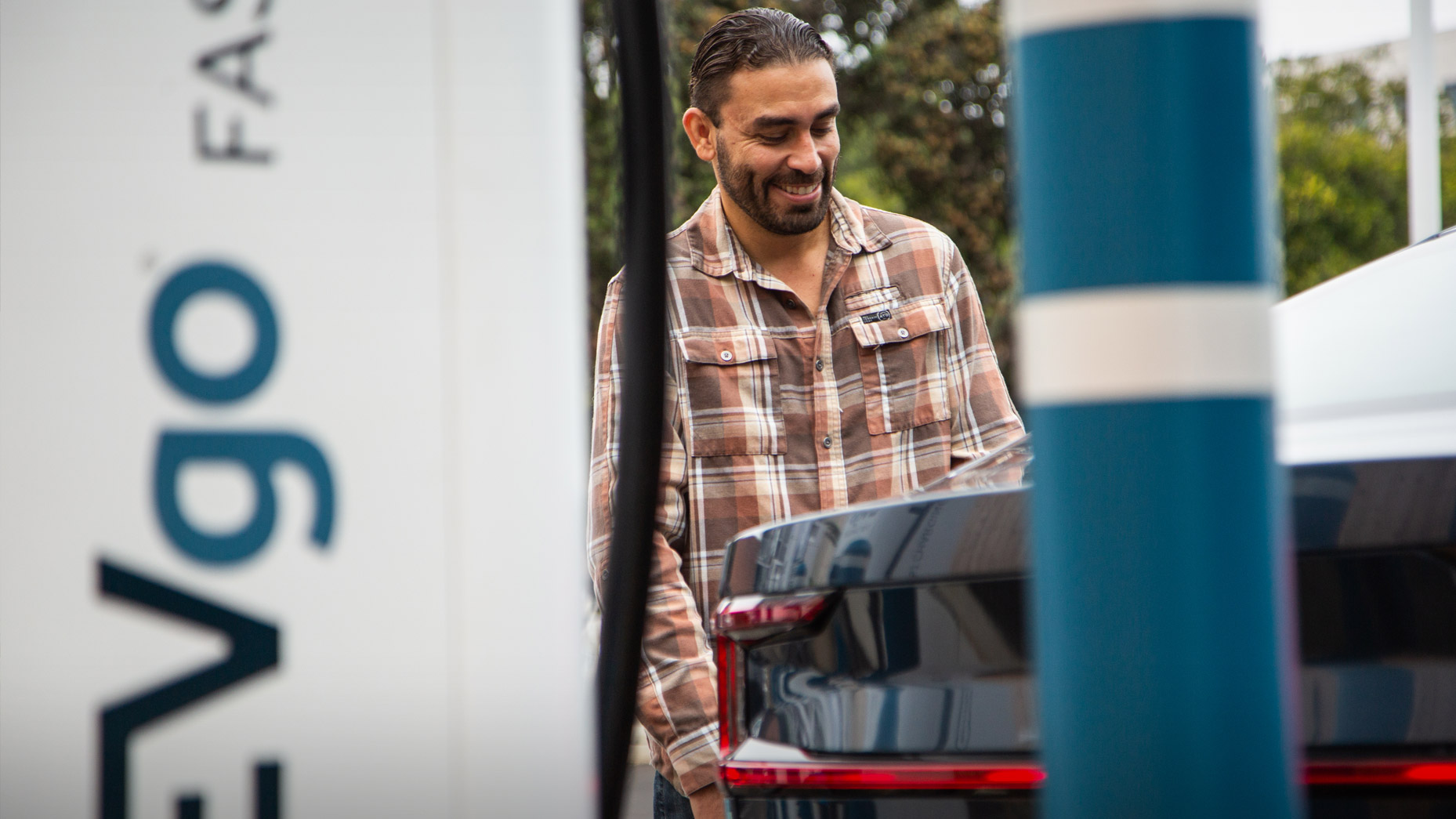 Man charging electric vehicle