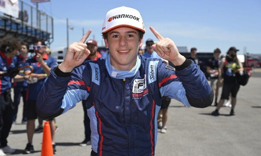 Young racer in uniform and hat