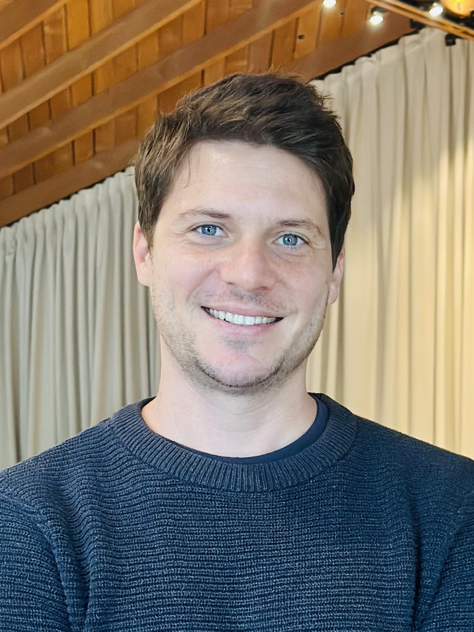 Man smiling in blue sweater