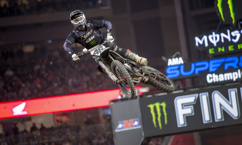 Motocross rider soaring during Supercross race