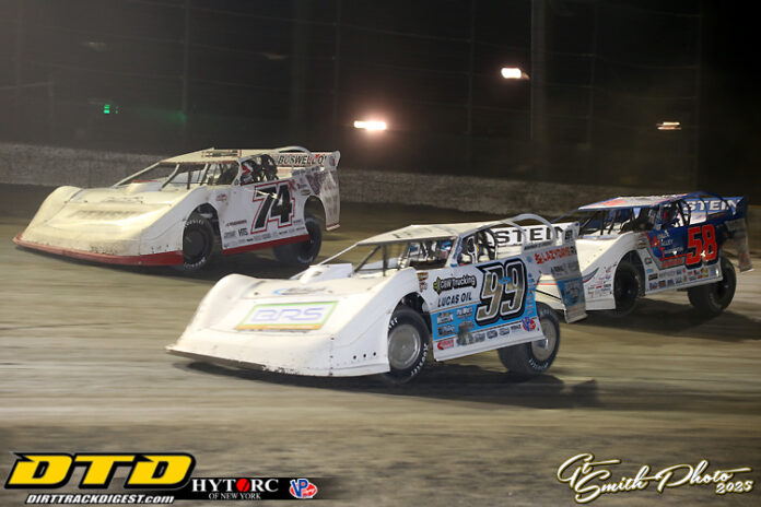 Three dirt track racecars competing