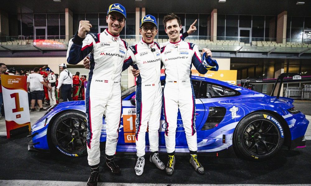 Three racing drivers in podium lineup