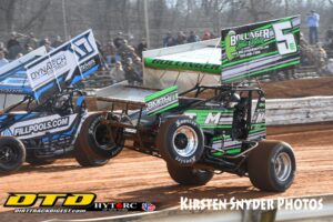 Two sprint cars racing on dirt