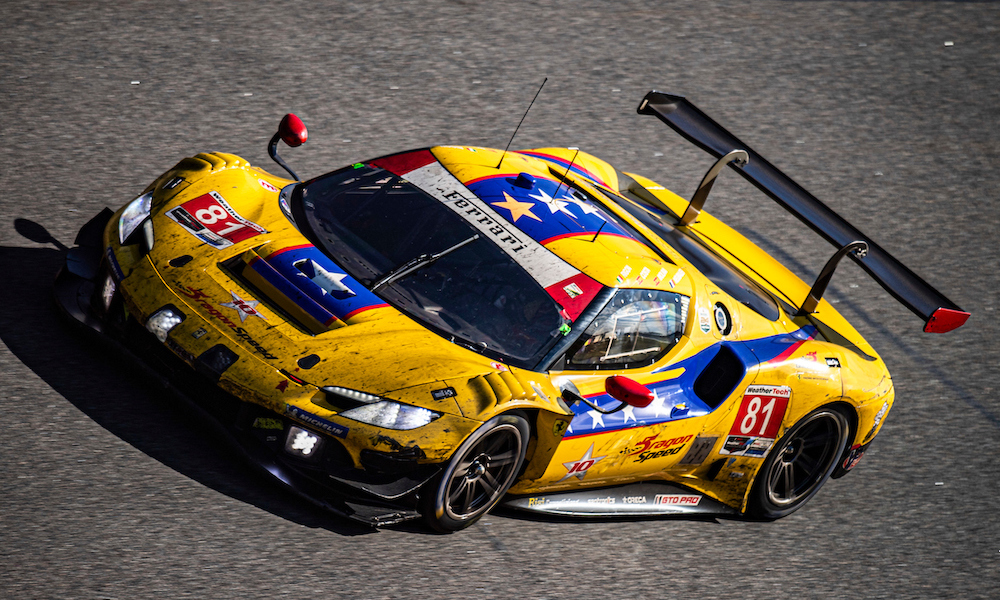 Yellow Ferrari racing at IMSA