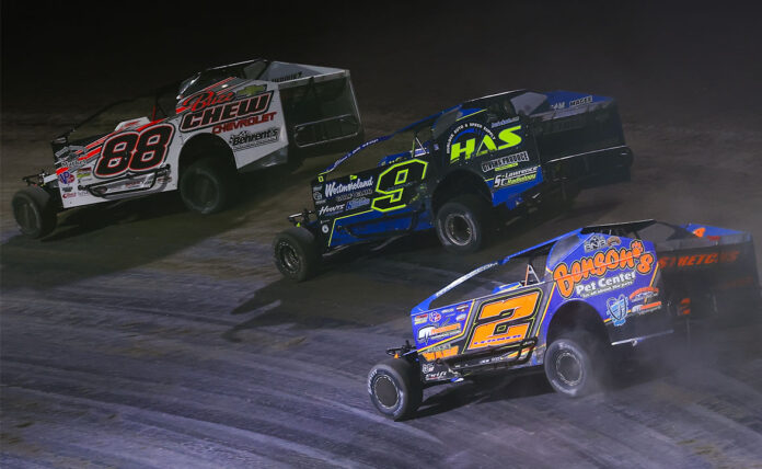 Three dirt track racers in action